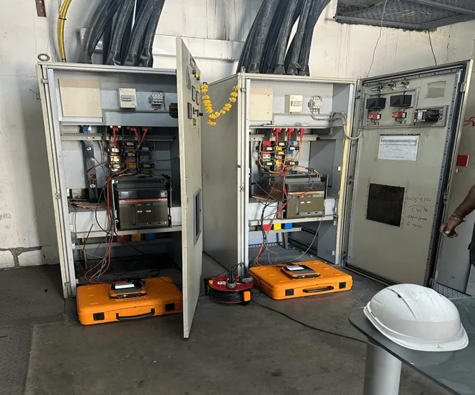 Two power quality analysers logging at an open switchboard during an audit