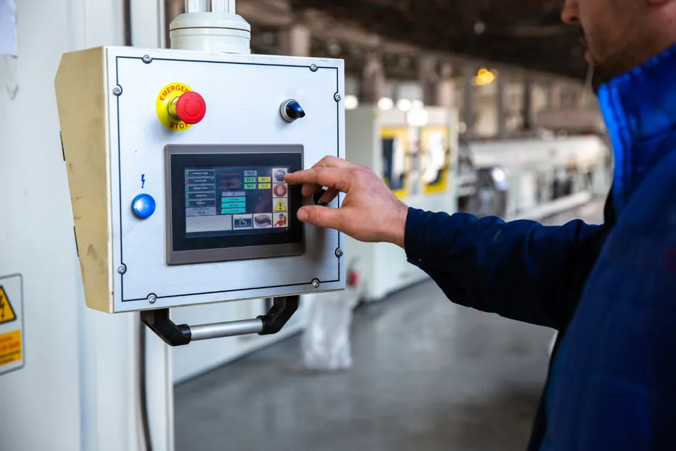 An operator using the touch panel of an industrial control cabinet